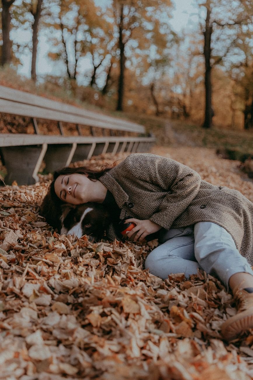 Woman relaxing in autumn leaves — a peaceful, hopeful moment